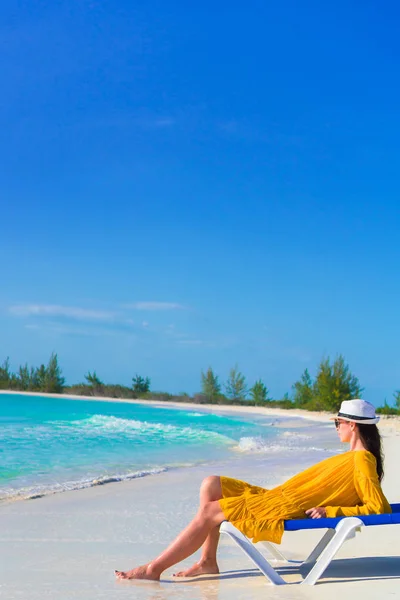 Mujer joven en una playa tropical relajándose en la tumbona — Foto de Stock