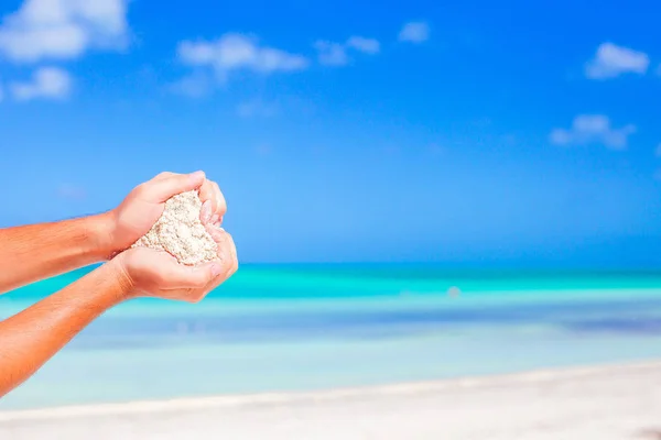 Closeup male hands holding white tropical beach form heart shape background the sea — Stock Photo, Image