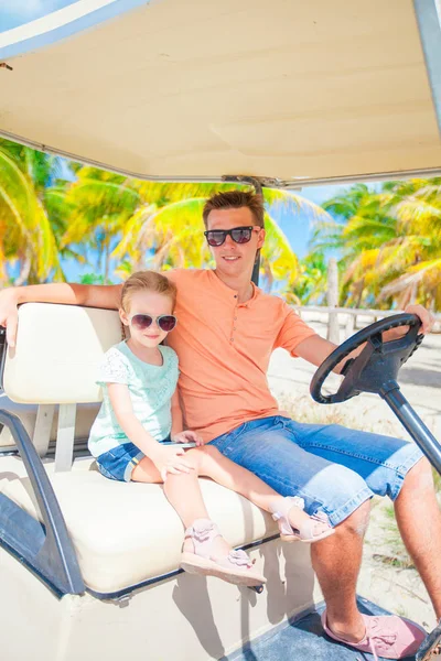 Kleines Mädchen mit Vater Golfwagen am tropischen Strand — Stockfoto