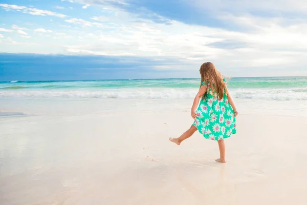 Increíble niña en la playa divirtiéndose mucho en las vacaciones de verano. Adorable niño saltando en la orilla del mar — Foto de Stock