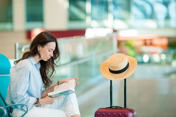 Jonge vrouw in een luchthaven lounge wachten voor vlucht vliegtuig. Kaukasische vrouw met smartphone in de wachtkamer — Stockfoto