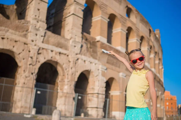 Adorable little girl having fun background of Colosseum in Rome, Italy. — Stock Photo, Image