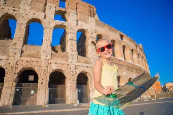 Adorable little active girl with map in front of Colosseum in Rome, Italy. Kid spending childhood in Europe — Stock Photo, Image