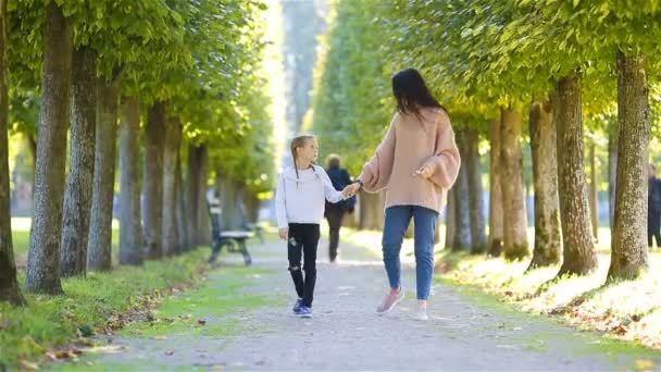 Familjen i höst. Ung mamma och liten unge promenader njuta av varm dag i höst park — Stockvideo