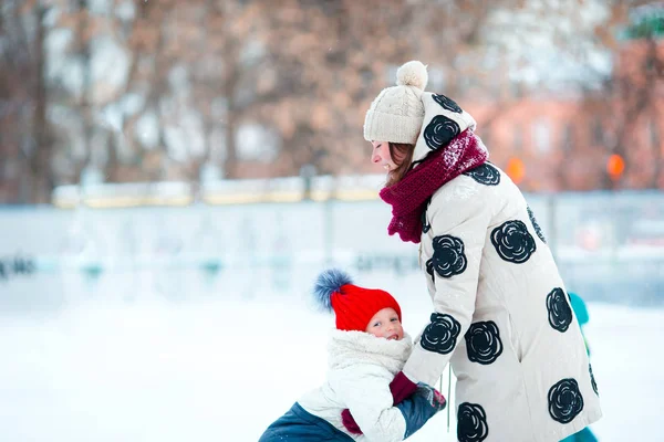 Niña adorable con madre patinando en pista de hielo con madre —  Fotos de Stock