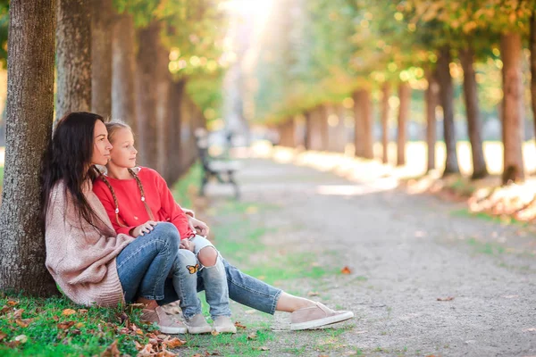 Familj med mor och liten unge utomhus i parken vid höstdag — Stockfoto