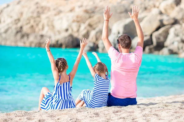 Baba ve çocuklar beyaz kumsalda