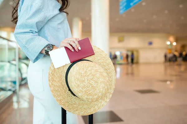 Primer plano de pasaportes y tarjeta de embarque en manos femeninas en el aeropuerto —  Fotos de Stock