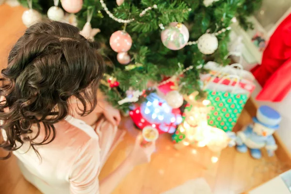 Mutlu genç kadın yakınındaki şenlikli köknar ağacı Noel arifesinde — Stok fotoğraf