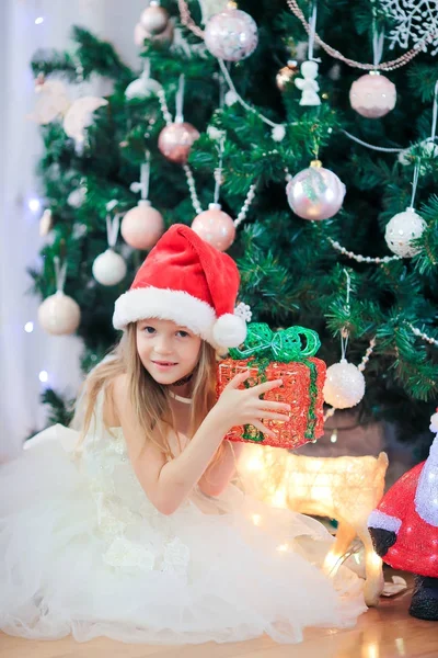 Liten söt flicka nära julgran. Barn under julgran med presentaskar. — Stockfoto