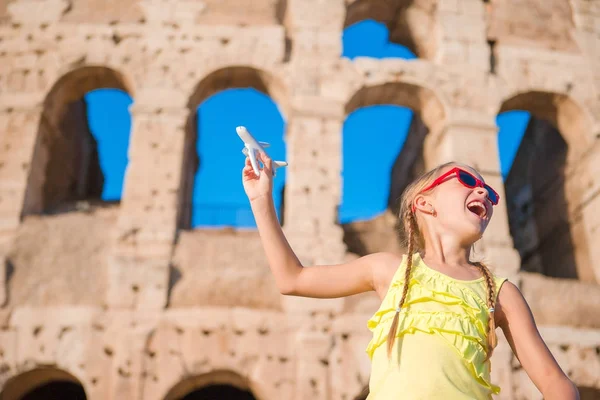 Adorable fille avec petit modèle de jouet fond d'avion Colisée à Rome, Italie — Photo