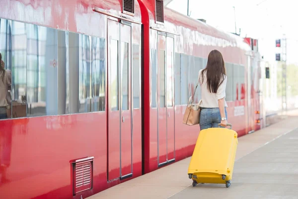 Обратный вид женщины с сумкой на вокзале, путешествующей на поезде — стоковое фото