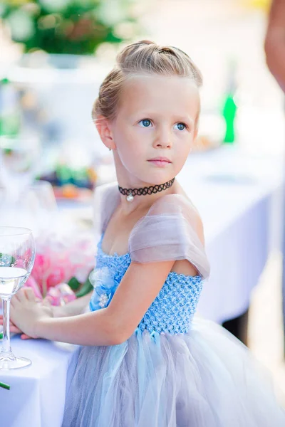 Adorable little girl in amazing dress at a wedding ceremony outdoors — Stock Photo, Image