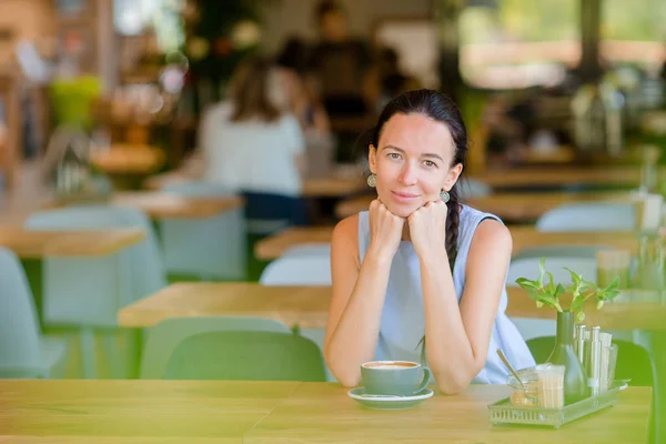 美丽的女人在户外咖啡馆吃早餐.快乐的城市年轻女子喝咖啡 — 图库照片