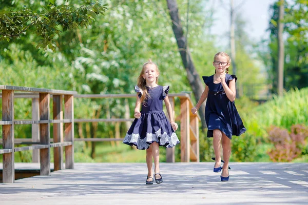 Entzückende kleine Schulmädchen im Freien an einem warmen Septembertag. Zurück zur Schule. — Stockfoto