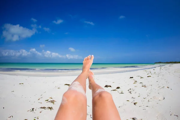 Kvinnliga fötter på vit sandstrand. — Stockfoto