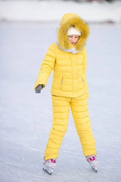 Красивая маленькая девочка собирается кататься на коньках в зимний снежный день на открытом воздухе — стоковое фото