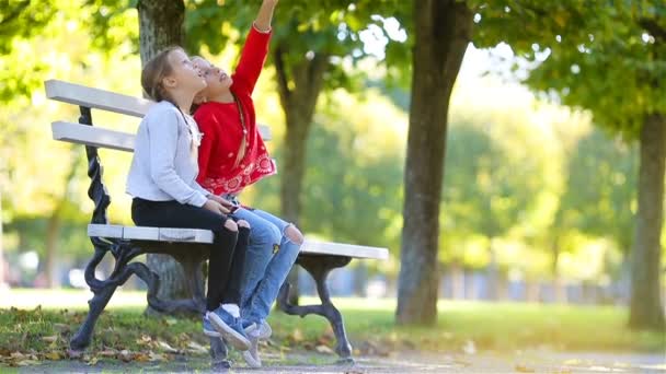 暖かい晴れた秋の日に屋外で楽しんでいる小さな愛らしい女の子。秋の子供たち. — ストック動画