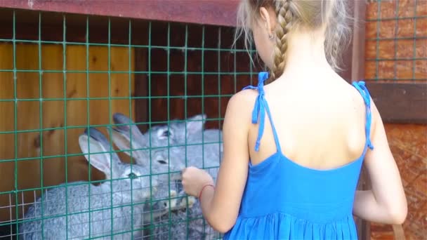 Voeding konijn. Meisje boerderij tamme konijnen vervoederen fleawort blad — Stockvideo