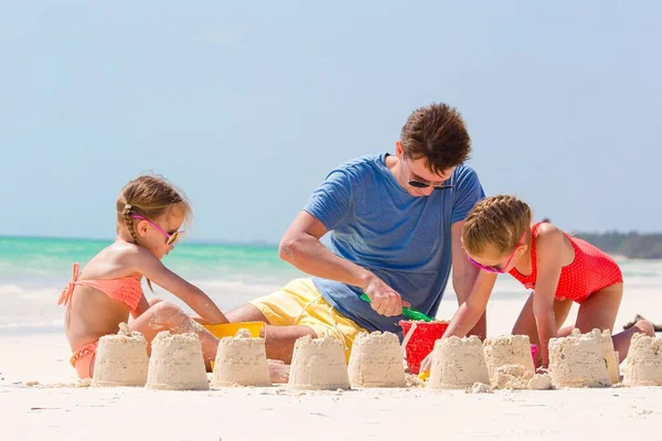 Vater und Kinder basteln Sandburg am tropischen Strand — Stockfoto