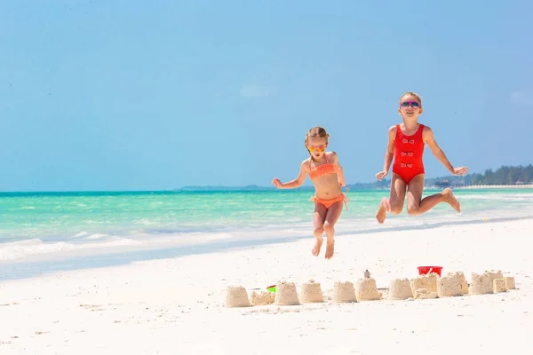 Yaz tatili sırasında sevimli küçük kızlar. Beyaz sahilde plaj oyuncakları ile oynarken çocuklar — Stok fotoğraf