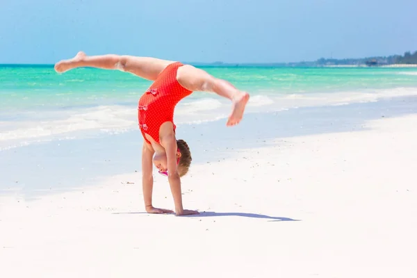 Actieve meisje op witte strand plezier. Closeup kid achtergrond de zee — Stockfoto