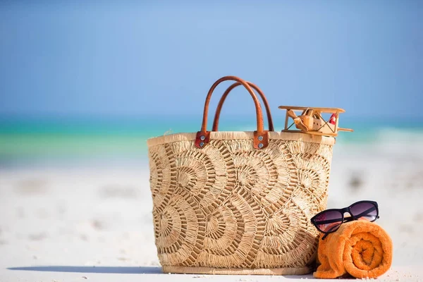 Strand accessoires - speelgoed vliegtuig, stro tas, oranje handdoek en unglasses op het strand — Stockfoto