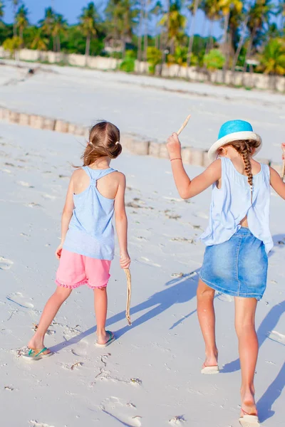 在夏天度假一起玩在浅水期间在热带海滩玩的小女孩 — 图库照片