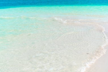 Pastoral tropikal plaj beyaz kum, turkuaz okyanus su ve güzel renkli gökyüzü Karayip Adası