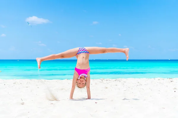 Active little girl at beach having a lot of fun on summer vacation. Adorable kid jumping on the seashore — Stock Photo, Image