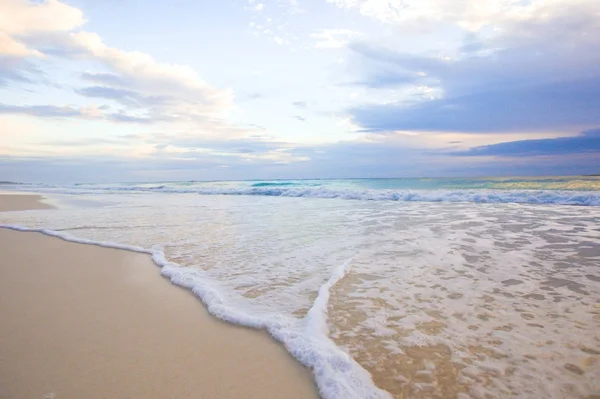 Idilli trópusi strand fehér homokos, türkizkék óceán víz és gyönyörű színes égbolt, a karibi szigeten — Stock Fotó