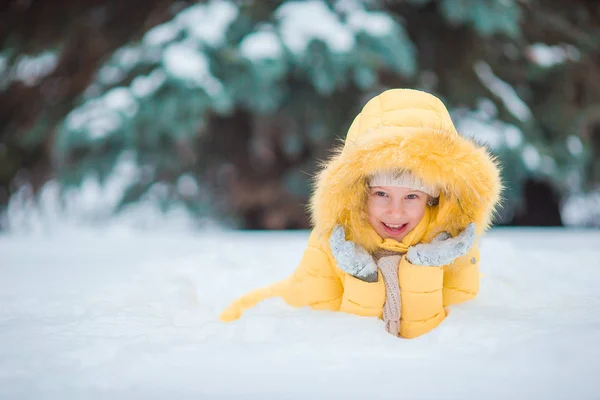 Portrait de petite fille adorable avec de beaux yeux verts dans la neige ensoleillée journée d'hiver — Photo