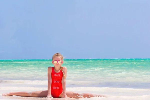 Aktives kleines Mädchen am weißen Strand, das Spaß hat — Stockfoto