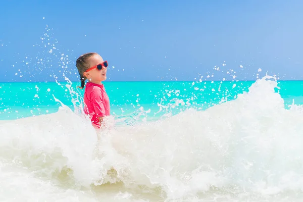 Rozkošná holčička na pláži mají spoustu zábavy ve vodě — Stock fotografie