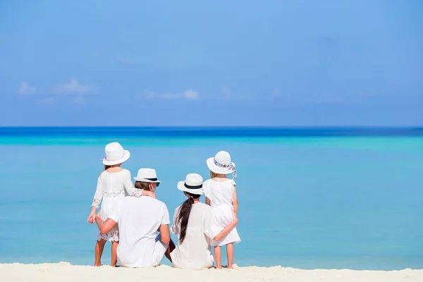 Вид ззаду щасливої сім'ї в білому на пляжі — стокове фото