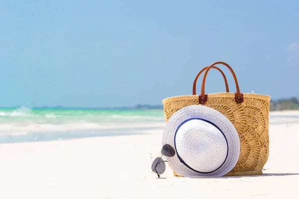 Accesorios de playa - bolsa de paja, sombrero y anteojos en la playa —  Fotos de Stock