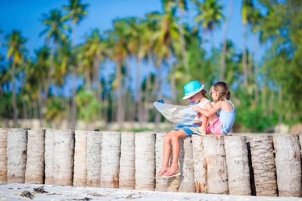 Adorable little girls with big map of island on beach — Stock Photo, Image