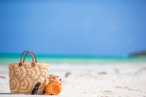 Accesorios de playa: avión de juguete, bolsa de paja, toalla naranja y anteojos en la playa — Foto de Stock