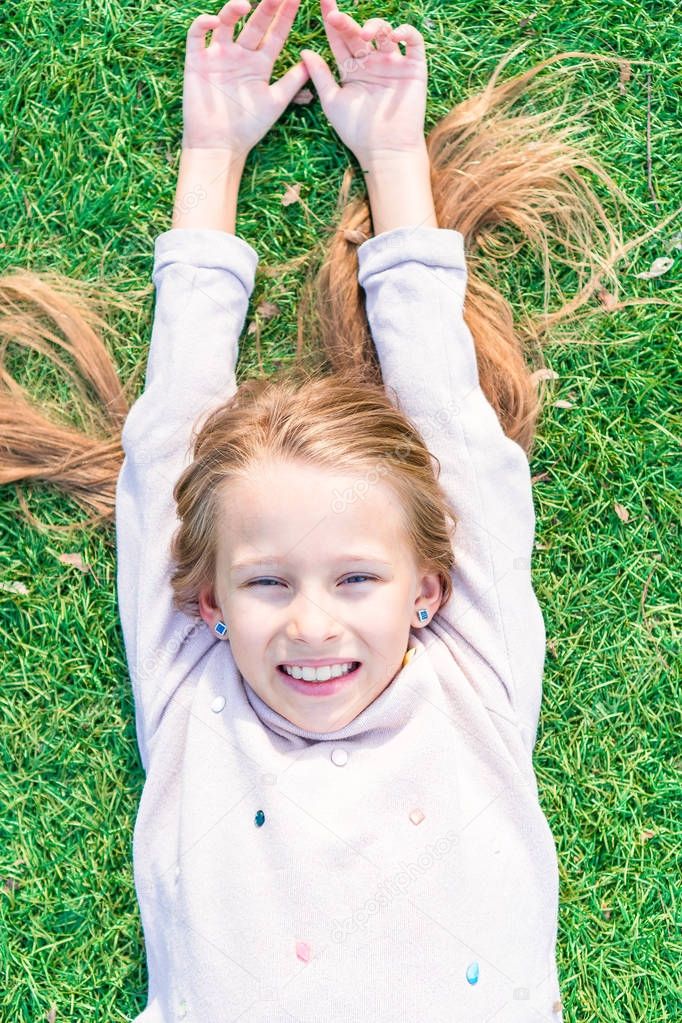 Adorable happy girl on green grass