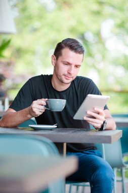 Smartphone anf açık kafede çay fincan genç çocuk. Hareket eden smartphone kullanan adam.