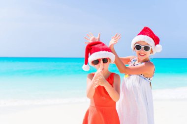 Çok güzel küçük çocuklar Santa şapka Noel beach tatil sırasında. Sahilde yeni yıl