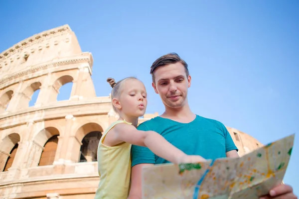 コロッセオの前で地図を持つ家族。父と魅力をお探しの女の子の背景のローマ、イタリアで有名なエリア — ストック写真