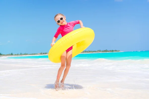 Criança feliz com círculo de borracha inflável se divertindo na praia branca — Fotografia de Stock