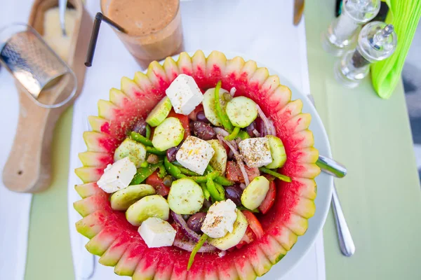 Pyszne świeże sałatki greckiej serwowane w porze lunchu w restauracji na świeżym powietrzu z pięknym widokiem na morze i port — Zdjęcie stockowe