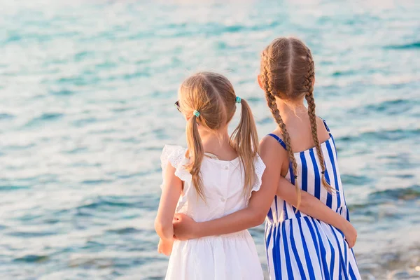 Adorable little girls at Little Venice the most popular tourist area on Mykonos island, Greece. Back view of beautiful kids look at Little Venice background. — Stock Photo, Image