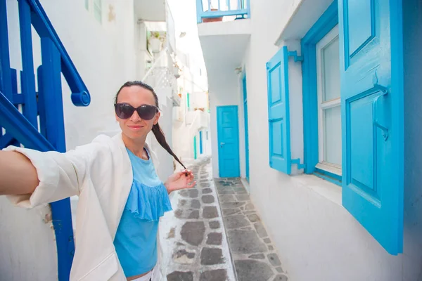 Jovem bela mulher tomando selfie com telefone ao ar livre fundo branco casa — Fotografia de Stock