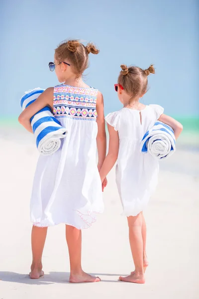 Красивые маленькие девочки с пляжными полотенцами на белом тропическом пляже — стоковое фото