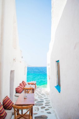 Mykonos 'taki tipik bir Yunan açık kafesinde, Cyclades adalarında deniz manzaralı yastıklı banklar.