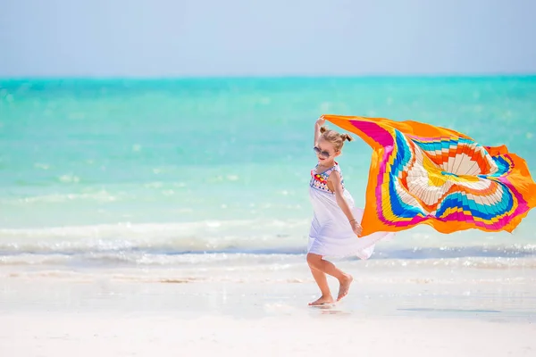 Feliz niña divirtiéndose corriendo con pareo en la playa tropical blanca —  Fotos de Stock