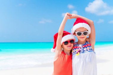 Çok güzel küçük çocuklar Santa şapka Noel beach tatil sırasında. Sahilde yeni yıl